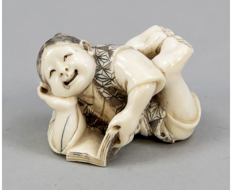 Netsuke, Japan, Ende 19. Jh. (Meiji). Auf dem Bauch liegendes, lesendes Mädchen mit geschwärzten Ritzdekoren. In geschwärzter