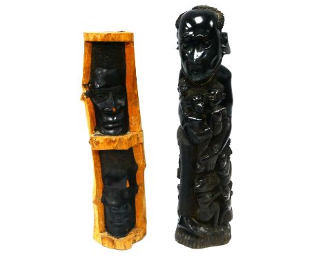Tribal Art; An African Hardwood Carving of a Seated Gentleman Holding Three Children, seven others by his feet, 40cm high and