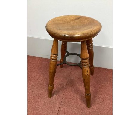 A Late XIX Century Birch Boston Stool, the gently dished circular seat supported by four turned legs united by an iron stretc
