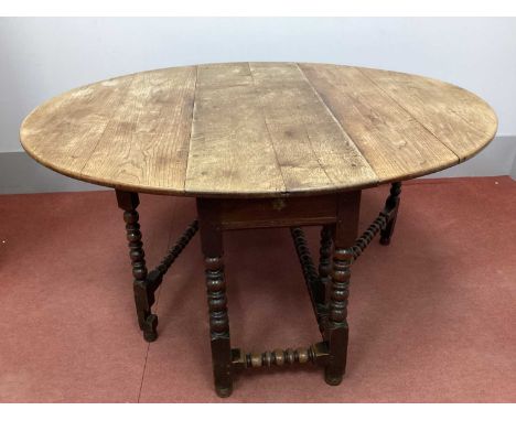 A Late XVII Century Joined Oak Drop Leaf Table, with oval top and single drawer on bobbin and block supports, 155cm wide.