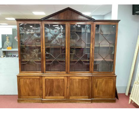 A George III Mahogany Breakfronted Library Bookcase, with triangular pediment, dentil cornice and glazed astragal doors, the 