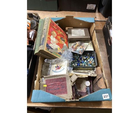 Box containing vintage marbles, a porcelain plaque, two annuals and a quantity of silk and glass slides