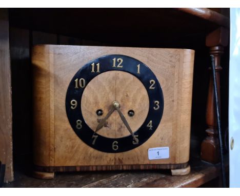 A Walnut Art Deco clock complete with key and pendulum.Condition - clock runs for a short while before stopping, general wear