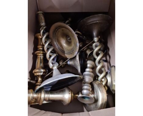 A box of brassware, mainly candlestick holders. 