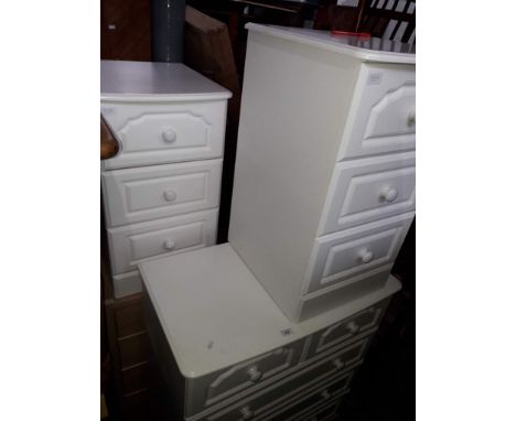 A white chest of drawers, two white bedside cabinets and a light wood effect bedside chest. 