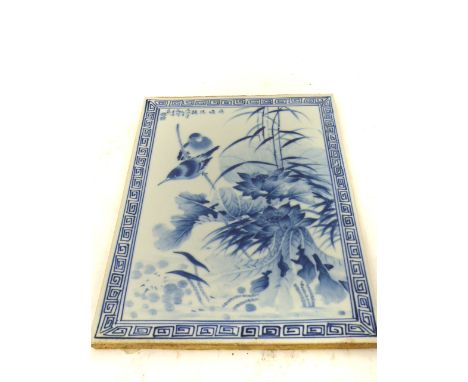An oriental 20th century, blue and white tile featuring birds with flowers; 36cm x 25cm.