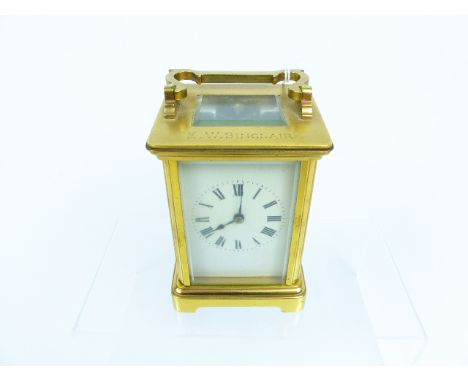A brass carriage clock with Roman numeral dial, engraved "EW Sinclair"; a/f.