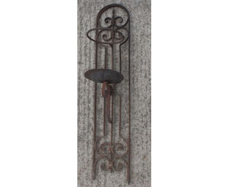 A wrought iron wall mounted candle holder, 36" high, and a black painted wrought iron hat and coat stand, on tripod base