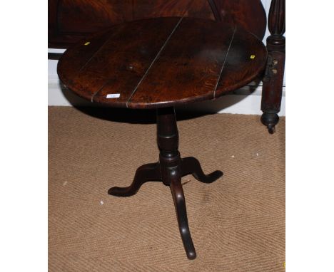 A late Georgian oak provincial planked circular tilt top table, on vase turned column and tripod splay supports, 29" dia