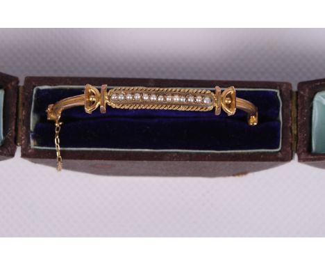 A 19th Century 9ct gold and seed pearl bangle, 5.4g