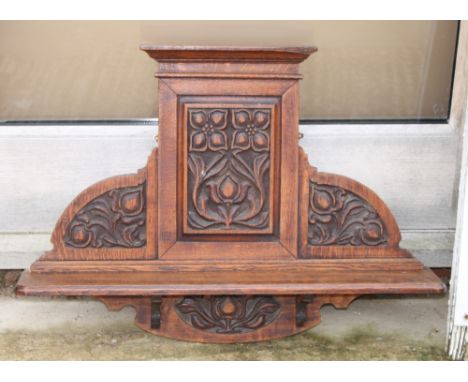 An Art Nouveau carved oak hall wall shelf with floral panel back, 27" wide