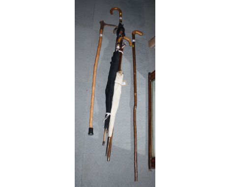 A palm wood walking cane with rolled gold mounts, a Royal Artillery swagger stick, a Malacca cane with silver mount, two meta