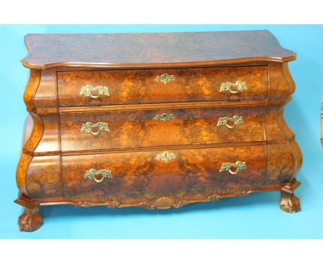 A reproduction walnut Dutch style bombe 3 drawer commode supported on lion paw feet.  119 cm wide