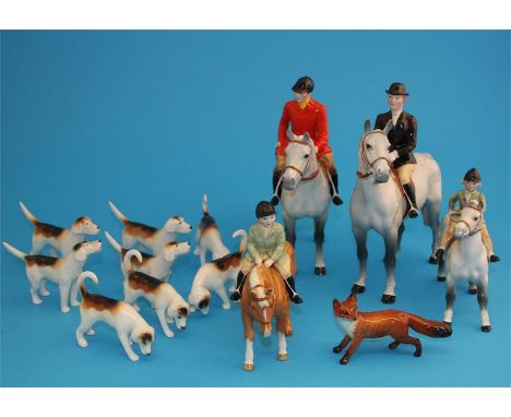 A Beswick hunting group comprising huntsman and huntswoman on dappled grey horses, a boy on a Palomino, the girl on a Skewbal