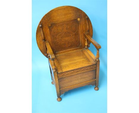 A small oak monk's bench with circular table top and rising seat.  75 cm diameter