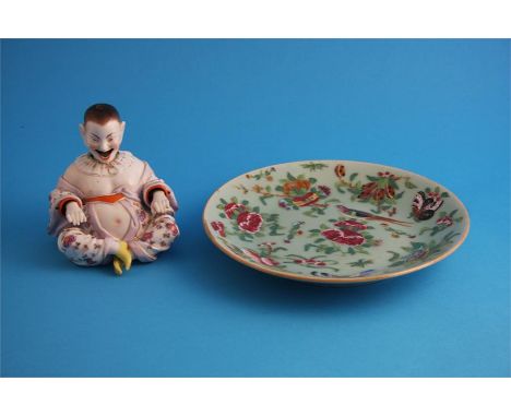 A Chinese Canton enamel circular plate and a porcelain seated Chinese nodding figure.  25 cm diameter and 14 cm high.