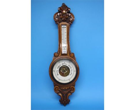 A carved oak 2 glass barometer.  89 cm long.