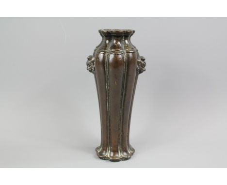 A Chinese Bronze Tapered Vase, the vase of segmented melon form with two taotie mask handles, approx 18 cms h, with Chinese s