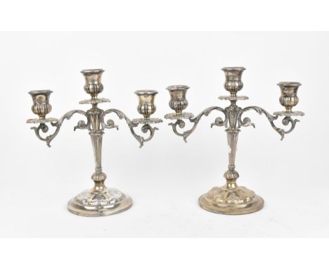 A pair of Italian silver candelabra, designed with twin-branch and central light, with acanthus scrolled arms on a tapered re