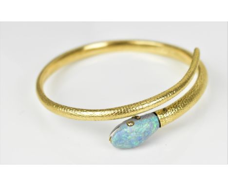 A yellow metal, diamond and opal serpent bangle, the body with textured effect mounted with a black opal head inset with diam