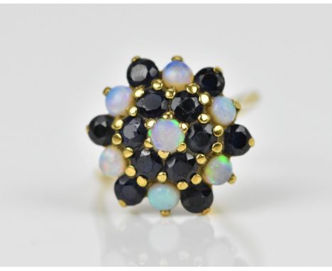 A yellow metal, blue sapphire and water opal dress ring, with cluster design of alternating cabochon opal and round cut sapph