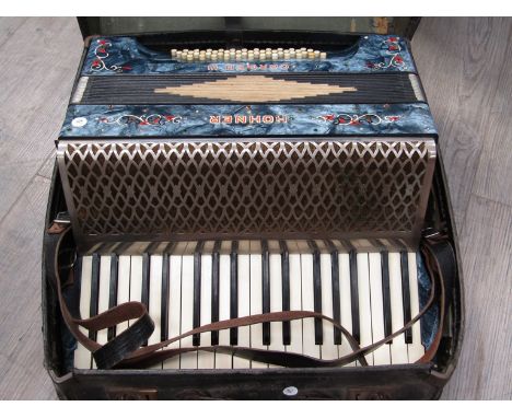 A Hohner Carmen III piano accordion, black body with multicoloured design, cased 