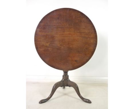 A George III mahogany tilt top circular occasional table, turned column, tripod base, carved knees and feet, 75 by 71cm high.