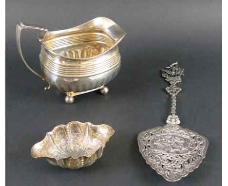 A Georgian cream jug, ribbed shoulders, angular handle and ball feet, marks very rubbed but duty mark visible, together with 