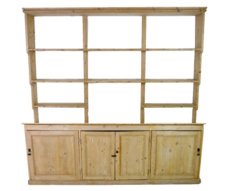 A large Victorian pine dresser, with three shelf waterfall plate rack above, three cupboards below with four doors, enclosing