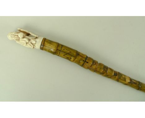 A bamboo sword stick, with carved bone handle modelled as a Chinese sage, 128cm long.