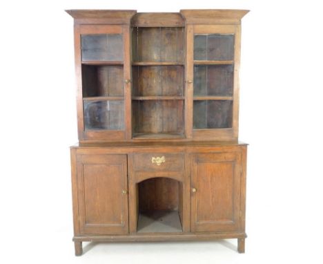 A late 18th century oak dresser, the upper section with cornice over two glazed cupboards enclosing two shelves, flaking two 