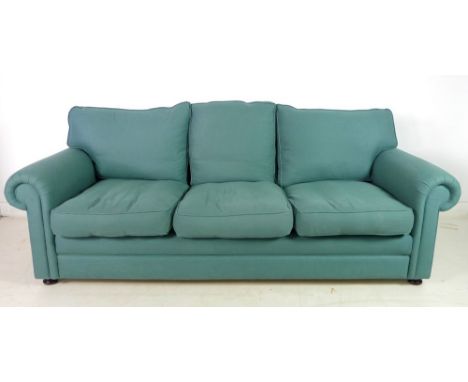 A modern three seater Chesterfield style sofa, with loose feather cushions, flattened bun feet, upholstered in sea green cott