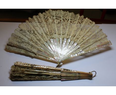 Two 19th Century mother of pearl and lace fans, both in poor condition, contained in embroidered fabric and card boxes respec