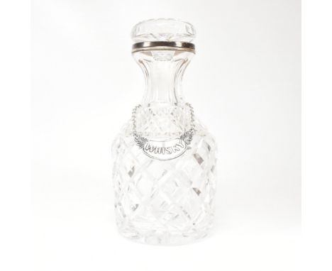 A George VI hallmarked silver collared cut glass decanter. Hallmarked for London, 1936.The decanter having a cut glass stoppe