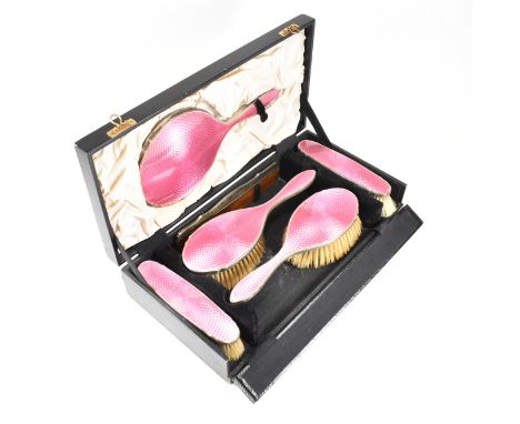 A 1920s cased five piece hallmarked silver mounted guilloche enamel vanity set. The George V dressing table set to include tw
