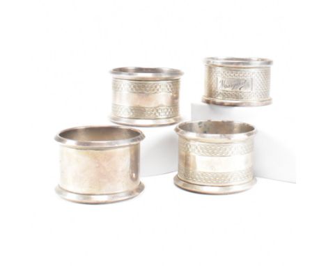 Four Early 20th century hallmarked silver napkin rings. The lot to include a pair of George V hallmarked silver napkin rings 