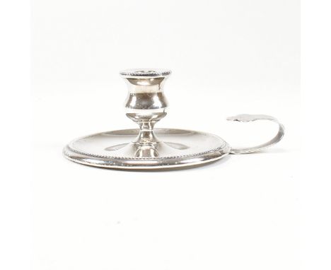 A Victorian hallmarked silver taperstick. The taperstick miniature chamber candle stick on a circular base with bead decorate