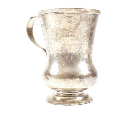 George V hallmarked silver trophy cup. The cup having a circular stepped plinth base raising to a bulbous form with scrolled 