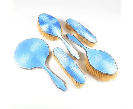 A 1920s five piece hallmarked silver and guilloche enamel vanity set. The set comprising of a hand mirror, two clothes brushe
