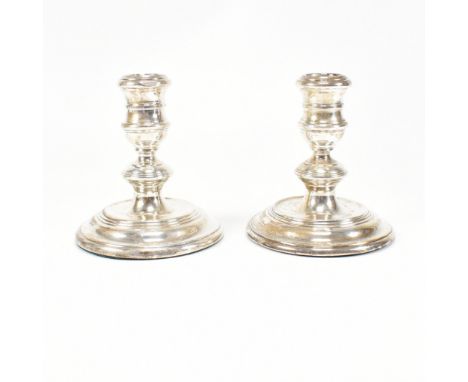 A pair of&nbsp; mid-century hallmarked silver squat candlesticks. The candlesticks having a weighted base and being of steppe