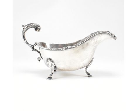 A George V hallmarked silver sauce boat. The sauce or gravy boat having three hoof feet raising to a bulbous form having a a 