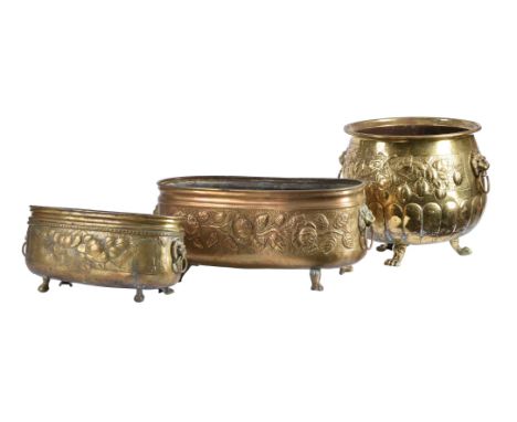 A circular embossed brass log bin, 19th century, with flanking lion mask ring handles, embossed fruit, gadrooned body and lio