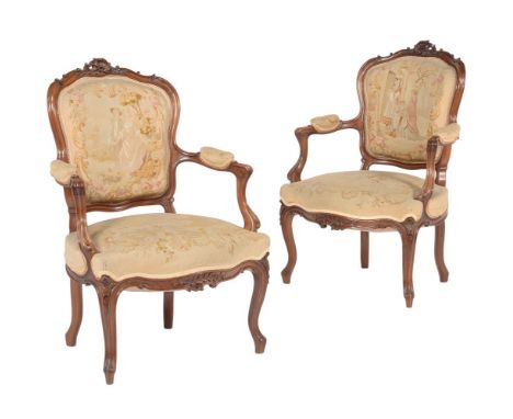 A pair of carved walnut armchairs in Louis XV style, 19th century, each with tapestry type upholstery 