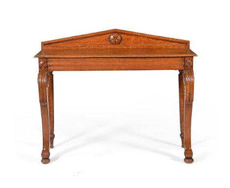 A William IV oak console table, circa 1835, carved with stylised flowerheads, the lappet carved front scrolling legs with rou