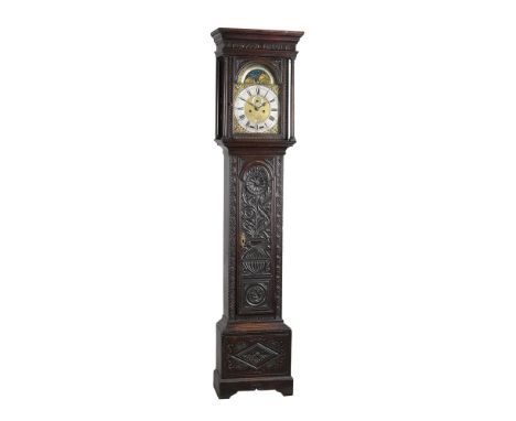 A carved oak longcase clock, with eight-day bell striking movement, the 12inch arched brass dial with applied spandrels to th