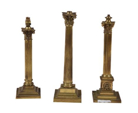 A group of three gilt brass columnar oil lamp bases, late 19th century, each modelled as a Corinthian column, 53cm high and s