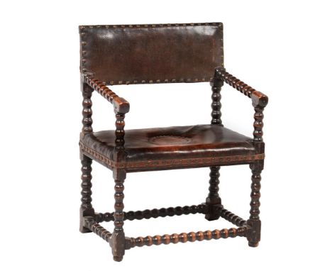 An oak and leather upholstered armchair, early 18th century and later,  with bobbin turnings throughout, 85cm highProvenance: