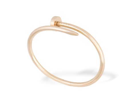 A GOLD JUSTE UN CLOU BANGLE, BY CARTIERDesigned as a hinged wraparound nail, in 18K rose gold, signed Cartier, numered, maker