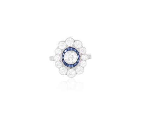 AN EARLY 20TH CENTURY SAPPHIRE AND DIAMOND CLUSTER RING, CIRCA 1920The old European-cut diamond within a border of calibré-cu