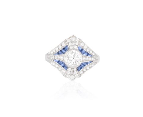 A DIAMOND AND SAPPHIRE DRESS RINGThe collet-set round brilliant-cut diamond within a frame of round brilliant-cut diamonds an